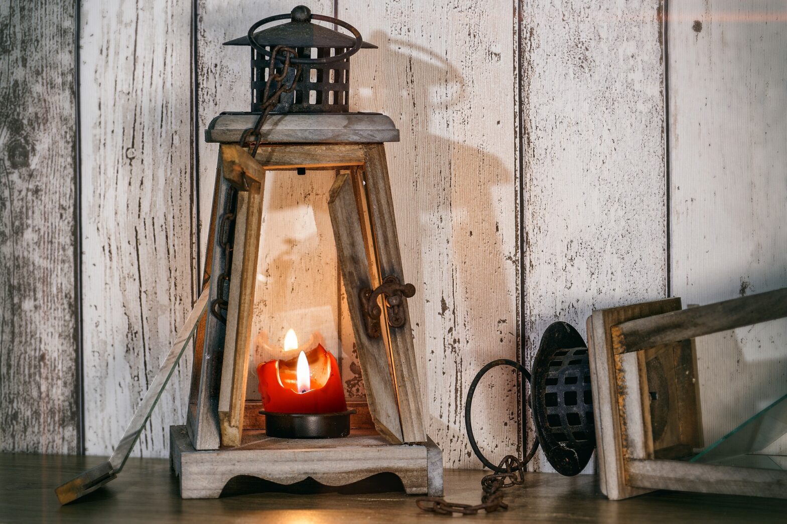 Wood and glass lantern with lit candle